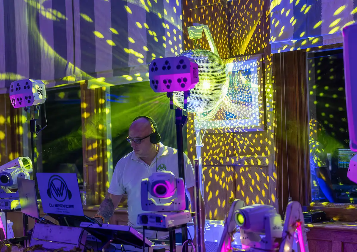 Cornwall DJ Leon Cashmore in the DJ booth with a classic retro mirror ball bouncing light around the room
