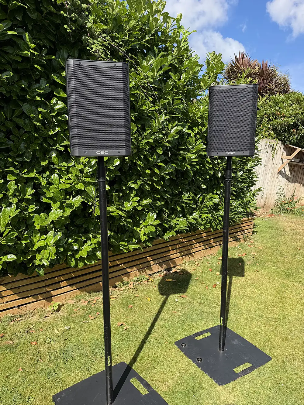 Outdoor rental PA system on stands in a garden